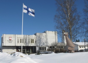 Kunnantalo talvimaisemassa, Suomen lipun liehuessa.