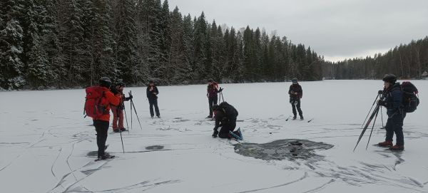 Omatoimiretki- ja apuvetäjäkurssilaiset tutkimassa jään vahvuutta ja rakennetta joulukuussa 2024.