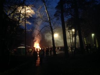 Kokko palaa kaukaisuudessa keskellä pimeää maisemaa.