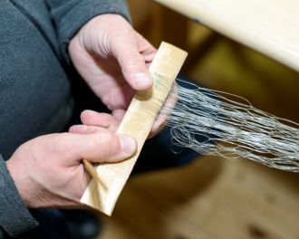 Lähikuva verkosta kutojan käsissä.