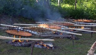 valokuva, jossa on kaksi varraslohta nuotion päällä.