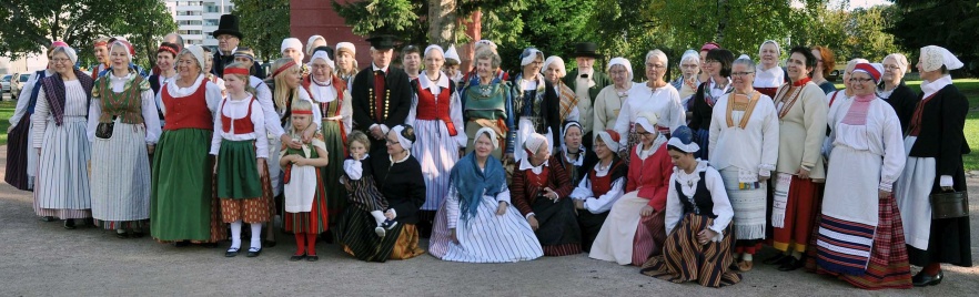 People wearing different kinds of Finnish national costumes.