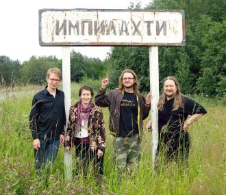 Iloinen orkesteri poseeraamassa tienvarsikyltin vieressä.
