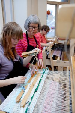 Making a rug with a loom.