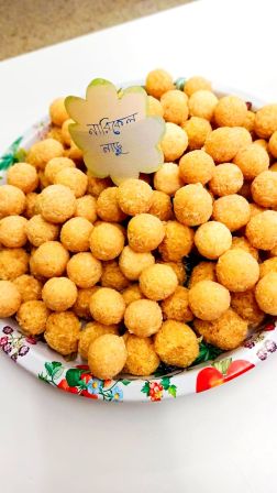 Lautasellinen vaaleita leivonnaisia, jotka on muotoiltu pieniksi palloiksi.