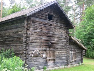 Tummanharmaa mökki.