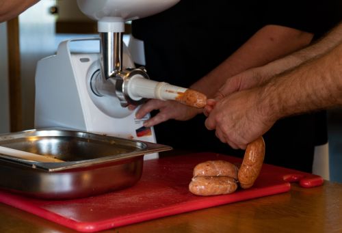 Kuvassa valmistetaan makkaraa makkarantekokoneella.