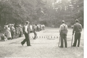Black and white picture of people playing skittles.