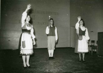 Mustavalkokuva kolmesta esiintyjästä viittomassa runoa.