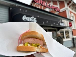 valokuva, jossa on porilainen kädessä. Taustalla näkyy grilli-pori.