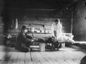 A black and white picture of two healers treating a customer.