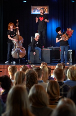 Koululaisia esiintymässä lavalla soittimien kanssa.