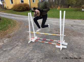 Hobby horse enthusiast jumping over a hurdle.