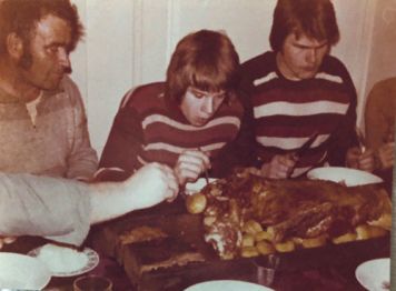 Vanha kuva nuorista miehistä ruokailemassa särää.