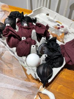 Decorated eggs wrapped in old thighs waiting to be put in decoction of natural dyes 2022