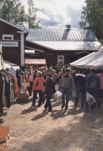 Markkinaväkeä punaisen työväentalon edessä.