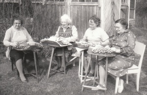 Mustavalkokuva neljästä naisesta nypläämässä pitsiä.