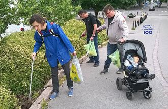 Ihmisiä keräämässä roskia puistossa.