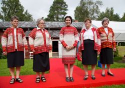 Folk som ler mot kameran i korsnäströjorna.
