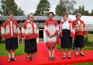 Ihmisiä hymyilemässä kameralle korsnäsipaidat yllään.