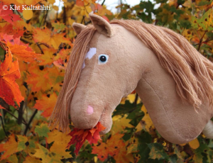 Hobby horse eating orange leaves.