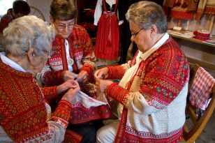 Kolme henkilöä tekevät korsnäsinpaitaa korsnäsinpaidat yllään.