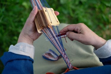 Kuvassa kudotaan Euran muinaispuvun hameen koristelautanauhaa.