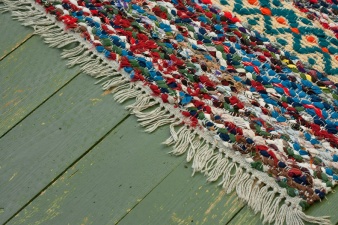Closeup of the fringed edge of a rag rug.