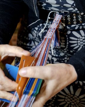 Kuvassa kudotaan monimutkaista lautanauhaa, jonka valmistaminen on rautakaudella vaatinut pitkälle kehittynyttä ammattitaitoa. Nykypäivänä kutojilla on apunaan erilaisia kuvallisia ja kirjallisia kudontaohjeita. Kuva: Riku Pasanen