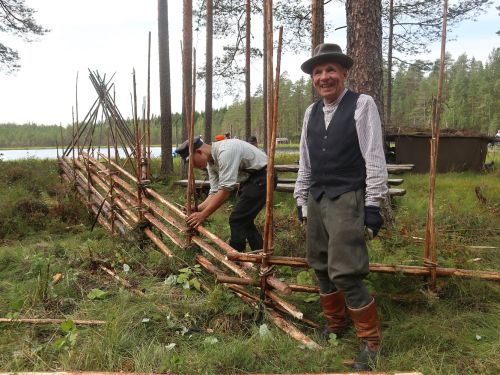 Riukuaidan rakentajat hymyileväisinä työn teossa.