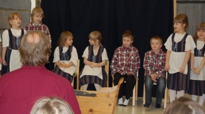 Children standing in a row and singing.