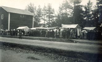Mustavalkokuva markkinateltoista ja väkijoukosta.